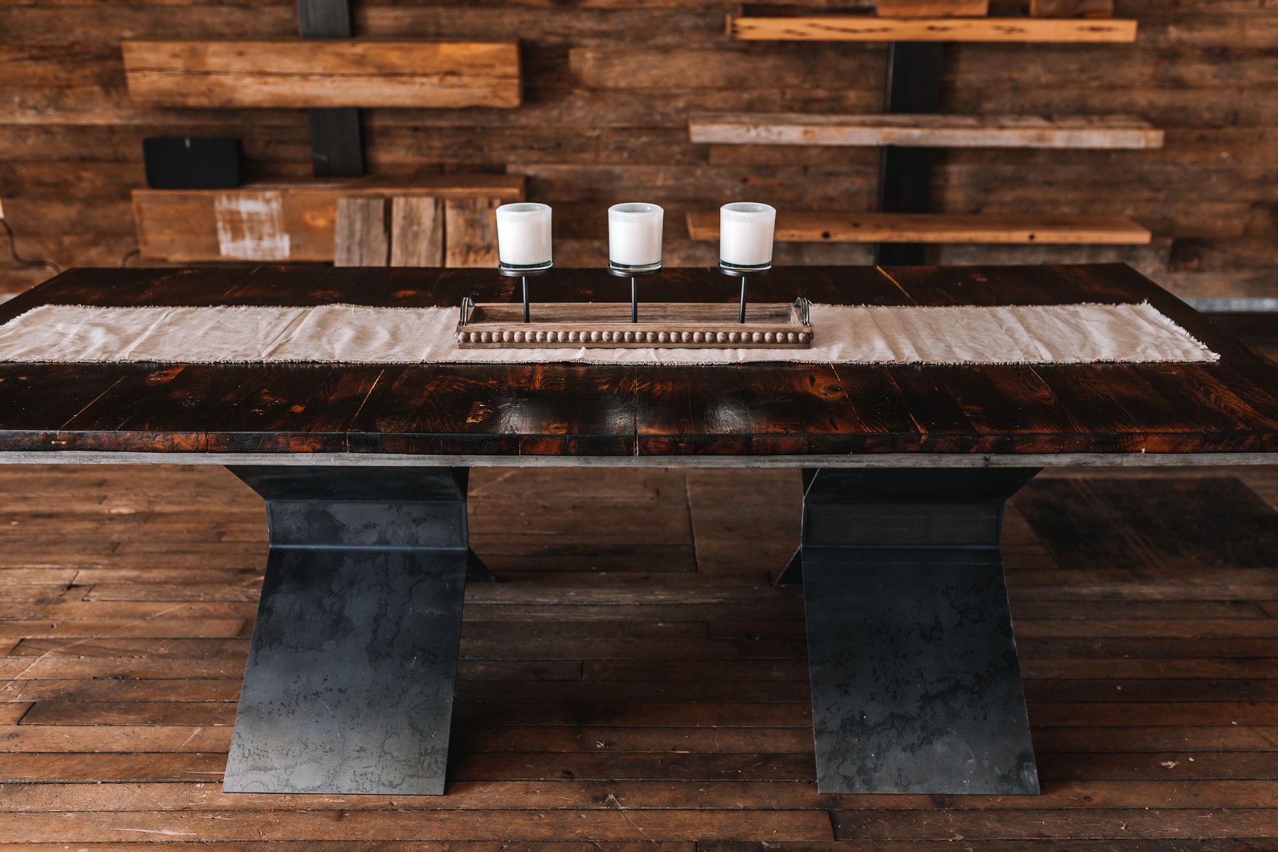 A custom reclaimed oak dining table on a blackened steel base