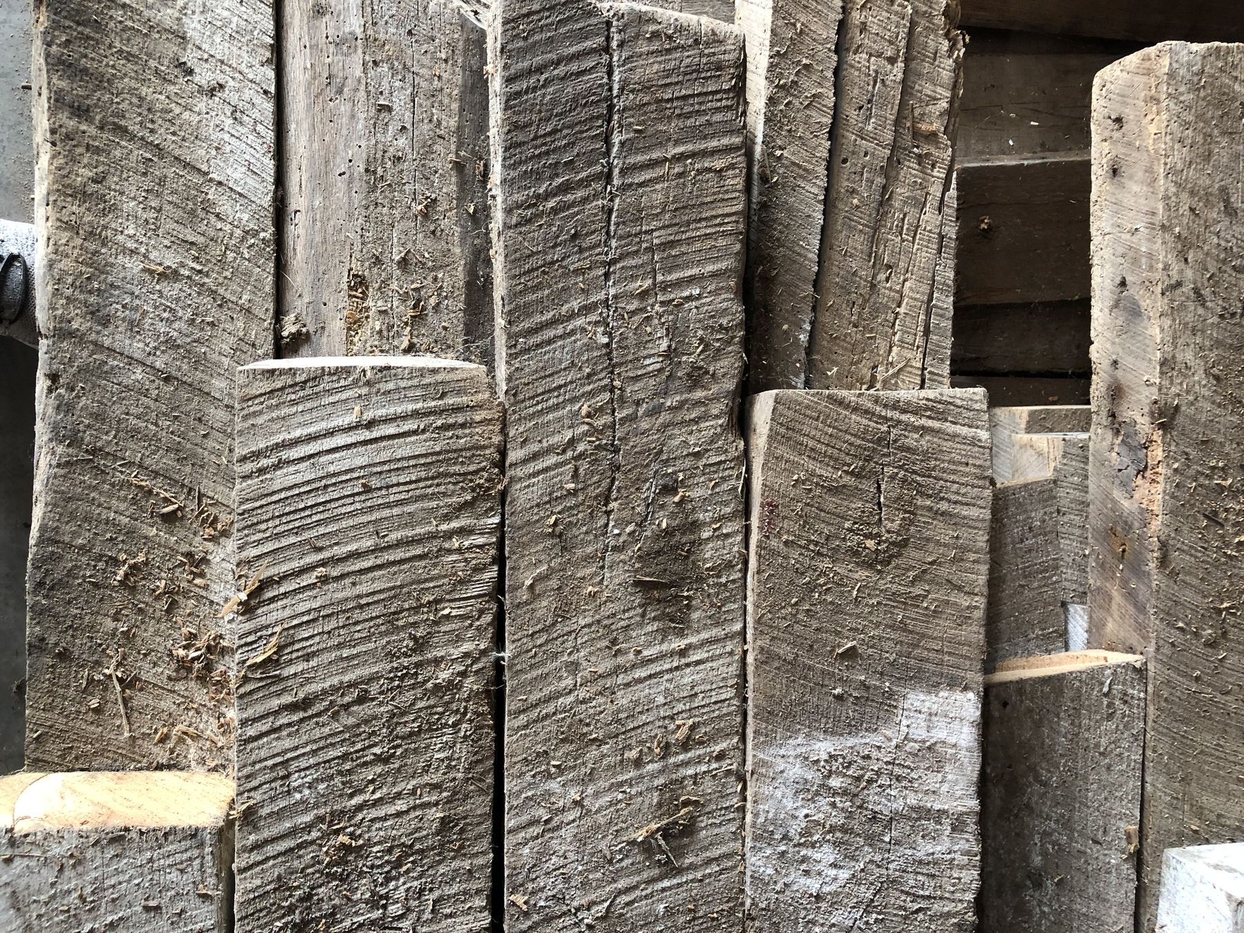 Weathered grey barn boards stacked in the yard