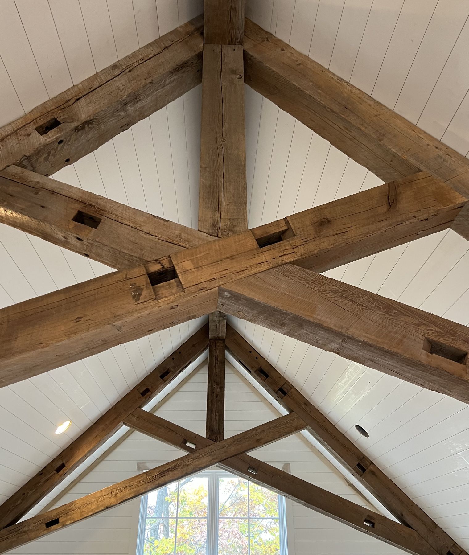 Reclaimed rough sawn timber trusses in a finished vaulted ceiling
